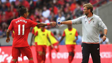 LONDON, ENGLAND - AUGUST 06: Jurgen Klopp, Manager of Liverpool gives a drink to Roberto Firmino of Liverpool during the International Champions Cup match between Liverpool and Barcelona at Wembley Stadium on August 6, 2016 in London, England. (Photo by Michael Regan/Getty Images)