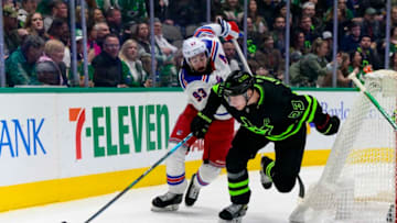 Mar 12, 2022; Dallas, Texas, USA; New York Rangers center Mika Zibanejad (93) and Dallas Stars defenseman Esa Lindell (23) chase the puck during the third period at the American Airlines Center. Mandatory Credit: Jerome Miron-USA TODAY Sports