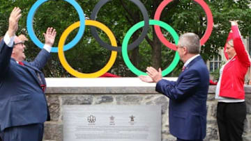 Jul 9, 2015; Montreal, CAN; Canadian Olympic Committee president Marcel Aubut (left) and International Olympic Committee president Thomas Bach (right) react as olympians Steve Podborski (left back row) and Emilie Heymans (right back row) unveil the Olympic rings during the Excellence Day at Canada Olympic House. Mandatory Credit: Jean-Yves Ahern-USA TODAY Sports