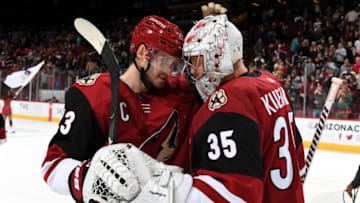 GLENDALE, ARIZONA - OCTOBER 17: Goalie Darcy Kuemper #35 of the Arizona Coyotes is congratulated by teammate Oliver Ekman-Larsson #23 following a 5-2 victory against the Nashville Predators at Gila River Arena on October 17, 2019 in Glendale, Arizona. (Photo by Norm Hall/NHLI via Getty Images)