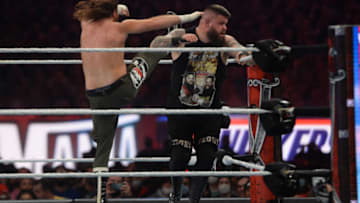 Apr 11, 2021; Tampa, Florida, USA; Sami Zayn (green attire) with LoganPaul (black Jacket) face Kevin Owens (black shirt/pant) during WrestleMania 37 at Raymond James Stadium. Mandatory Credit: Joe Camporeale-USA TODAY Sports