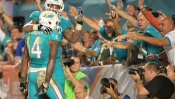 Nov 13, 2014; Miami Gardens, FL, USA; Miami Dolphins guard Mike Pouncey (51) celebrates after wide receiver Jarvis Landry (14) scored a touchdown against the Buffalo Bills during the second half at Sun Life Stadium. The Dolphins won 22-9. Mandatory Credit: Steve Mitchell-USA TODAY Sports