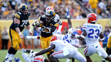 TAMPA, FL - JANUARY 2: Running back Akrum Wadley #25 of the Iowa Hawkeyes breaks a tackle by defensive back Duke Dawson #7 of the Florida Gators during a carry in the second quarter of the Outback Bowl NCAA college football game on January 2, 2017 at Raymond James Stadium in Tampa, Florida. (Photo by Brian Blanco/Getty Images)