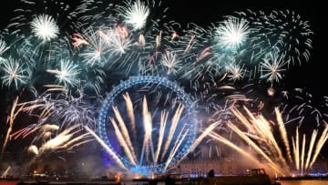 LONDON, ENGLAND - JANUARY 01: Fireworks explode near the giant Ferris wheel of the London Eye on the South Bank of the River Thames as thousands gather to ring in the near year on January 1, 2018 in London, England. Crowds lined the banks of the River Thames in central London to see in 2018 with a spectacular fireworks display. (Photo by Jack Taylor/Getty Images)