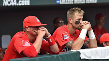 Omaha, NE - JUNE 30: Player J.J. Matijevic (R) of the Arizona Wildcats and a teammate look on from the dugout, as the Coastal Carolina Chanticleers celebrate on the field after winning the National Championship at the College World Series Championship Series on June 30, 2016 at TD Ameritrade Park in Omaha, Nebraska. (Photo by Peter Aiken/Getty Images)