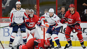 RALEIGH, NC - JANUARY 12: Carolina Hurricanes Left Wing Brock McGinn (23) is knocked to the ice by Washington Capitals Defenceman Matt Niskanen (2) in front of Carolina Hurricanes Goalie Cam Ward (30) during a game between the Washington Capitals and the Carolina Hurricanes at the PNC Arena in Raleigh, NC on January 12, 2018. Washington defeated Carolina 4-3. (Photo by Greg Thompson/Icon Sportswire via Getty Images)
