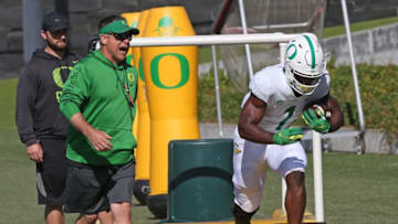 Oregon football coach Jim Mastro, left, calls to running back Trey Benson during fall camp.Eug 082421 Benson