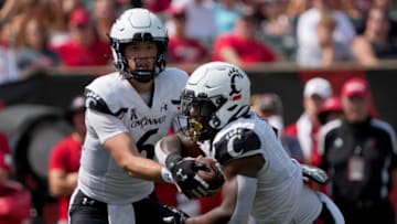 Ben Bryant of the Cincinnati Bearcats hands the ball off to Corey Kiner against the Miami (OH) RedHawks. Getty Images.