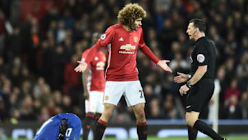 Manchester United's Belgian midfielder Marouane Fellaini (C) gestures to English referee Neil Swarbrick (R) as Everton's Senegalese midfielder Idrissa Gueye clutches his side during the English Premier League football match between Manchester United and Everton at Old Trafford in Manchester, north west England, on April 4, 2017. / AFP PHOTO / Oli SCARFF / RESTRICTED TO EDITORIAL USE. No use with unauthorized audio, video, data, fixture lists, club/league logos or 'live' services. Online in-match use limited to 75 images, no video emulation. No use in betting, games or single club/league/player publications. / (Photo credit should read OLI SCARFF/AFP/Getty Images)