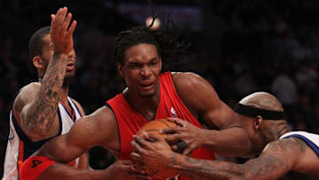 NEW YORK - JANUARY 28: Chris Bosh #4 of the Toronto Raptors drives to the basket between Wilson Chandler #21 and Al Harrington #1 of the New York Knicks at Madison Square Garden on January 28, 2010 in New York, New York. NOTE TO USER: User expressly acknowledges and agrees that, by downloading and or using this photograph, User is consenting to the terms and conditions of the Getty Images License Agreement. (Photo by Nick Laham/Getty Images)