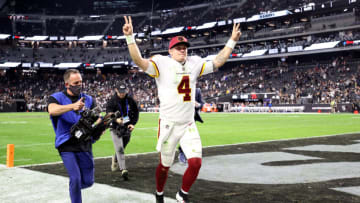 LAS VEGAS, NEVADA - DECEMBER 05: Taylor Heinicke #4 of the Washington Football Team raises his arms as he jogs off the field after the game against the Las Vegas Raiders at Allegiant Stadium on December 05, 2021 in Las Vegas, Nevada. (Photo by Ronald Martinez/Getty Images)