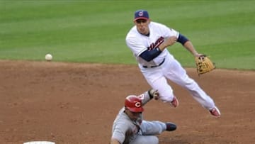 May 30, 2013; Cleveland, OH, USA; Cleveland Indians shortstop Asdrubal Cabrera (13) turns a double play over Cincinnati Reds shortstop Cesar Izturis (3) in the third inning at Progressive Field. Mandatory Credit: David Richard-USA TODAY Sports
