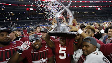 Dec 31, 2015; Arlington, TX, USA; Alabama Crimson Tide defensive back Cyrus Jones (5) hoists the Cotton Bowl championship trophy after defeating the Michigan State Spartans in the 2015 CFP semifinal at the Cotton Bowl at AT&T Stadium. Mandatory Credit: Tim Heitman-USA TODAY Sports