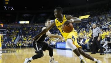 Dec 23, 2015; Ann Arbor, MI, USA; Michigan Wolverines guard Caris LeVert (23) moves the ball on Bryant University Bulldogs guard Shane McLaughlin (4) in the first half at Crisler Center. Mandatory Credit: Rick Osentoski-USA TODAY Sports