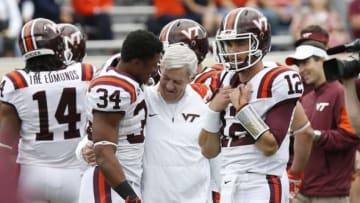 Nov 28, 2015; Charlottesville, VA, USA; Virginia Tech Hokies head coach Frank Beamer (M) talks with Hokies running back Travon McMillian (34) and Hokies quarterback Michael Brewer (12) during warmups prior to the Hokies game against the Virginia Cavaliers at Scott Stadium. The Hokies won 23-20. Mandatory Credit: Geoff Burke-USA TODAY Sports