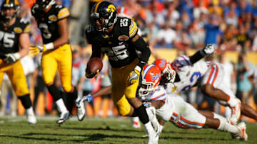 TAMPA, FL - JANUARY 2: Running back Akrum Wadley #25 of the Iowa Hawkeyes slips a tackle by defensive back Marcell Harris #26 of the Florida Gators during a carry in the third quarter of the Outback Bowl NCAA college football game on January 2, 2017 at Raymond James Stadium in Tampa, Florida. (Photo by Brian Blanco/Getty Images)