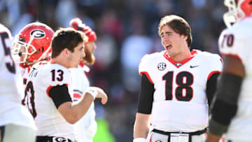 ATLANTA, GA - NOVEMBER 27: Stetson Bennett #13 of the Georgia Bulldogs talks with JT Daniels #18 on the side lines during the second quarter against the Georgia Tech Yellow Jackets at Bobby Dodd Stadium on November 27, 2021 in Atlanta, Georgia. (Photo by Adam Hagy/Getty Images)