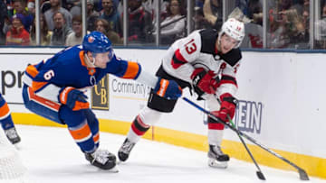 UNIONDALE, NY - JANUARY 02: New Jersey Devils Center Nico Hischier (13) passes the puck with New York Islanders Defenseman Ryan Pulock (6) defending during the third period of the National Hockey League game between the New Jersey Devils and the New York Islanders on January 2, 2020, at the Nassau Veterans Memorial Coliseum in Uniondale, NY. (Photo by Gregory Fisher/Icon Sportswire via Getty Images)