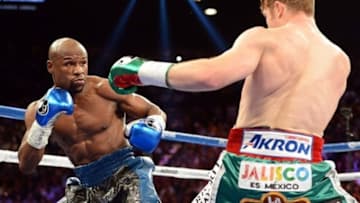 Sep 14, 2013; Las Vegas, NV, USA; Floyd Mayweather Jr. (blue gloves) and Canelo Alvarez battle during their during their WBC and WBA super welterweight titles fight at MGM Grand Garden Arena. Mandatory Credit: Jayne Kamin-Oncea-USA TODAY Sports