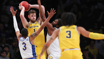 Nov 16, 2022; Brooklyn, New York, USA; Michigan Wolverines center Hunter Dickinson (1) protects the ball from Pittsburgh Panthers guard Greg Elliott (3) and forward John Hugley IV (4) during the second half at Barclays Center. Mandatory Credit: Vincent Carchietta-USA TODAY Sports