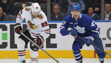 TORONTO, CANADA - FEBRUARY 15: Andreas Athanasiou #89 of the Chicago Blackhawks grabs a puck in front of Pierre Engvall #47 of the Toronto Maple Leafs during an NHL game at Scotiabank Arena on February 15, 2023 in Toronto, Ontario, Canada. The Maple Leafs defeated the Blackhawks 5-2. (Photo by Claus Andersen/Getty Images)