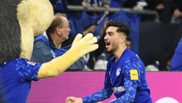 Schalke's German midfielder Suat Serdar celebrates with mascot Erwin scoring the opening goal 1-0 during the German first division Bundesliga football match FC Schalke 04 vs FC Cologne in Gelsenkirchen, western Germany, on October 5, 2019. (Photo by INA FASSBENDER / AFP) / DFL REGULATIONS PROHIBIT ANY USE OF PHOTOGRAPHS AS IMAGE SEQUENCES AND/OR QUASI-VIDEO (Photo by INA FASSBENDER/AFP via Getty Images)