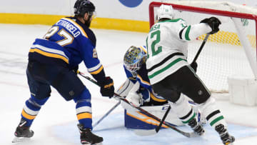ST. LOUIS, MO - APRIL 25: Dallas Stars center Radek Faksa (12) tries to jam the puck past St. Louis Blues goalie Jordan Binnington (50) as St. Louis Blues defenseman Alex Pietrangelo (27) defends during a second round Stanley Cup Playoffs game between the Dallas Stars and the St. Louis Blues, on April 25, 2019, at Enterprise Center, St. Louis, Mo. (Photo by Keith Gillett/Icon Sportswire via Getty Images)
