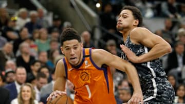 SAN ANTONIO, TX - JANUARY 24: Devin Booker #1 of the Phoenix Suns drives around Bryn Forbes #11 of the San Antonio Spurs during an NBA game at the AT&T Center on January 24, 2020 in San Antonio, Texas. NOTE TO USER: User expressly acknowledges and agrees that, by downloading and or using this photograph, User is consenting to the terms and conditions of the Getty Images License Agreement. (Photo by Edward A. Ornelas/Getty Images)