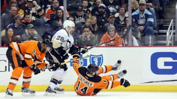 Apr 3, 2016; Pittsburgh, PA, USA; Philadelphia Flyers center Sean Couturier (14) reaches for the puck after being knocked down by Pittsburgh Penguins defenseman Ian Cole (28) during the first period at the CONSOL Energy Center. Mandatory Credit: Charles LeClaire-USA TODAY Sports