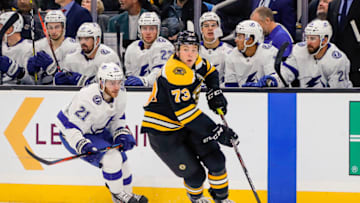 BOSTON, MA - OCTOBER 17: Boston Bruins defenseman Charlie McAvoy (73) skates with the puck as Tampa Bay Lightning center Brayden Point (21) trails the play near Lightning bench during the Tampa Bay Lightning and Boston Bruins NHL game on October 17, 2019, at TD Garden in Boston, MA. (Photo by John Crouch/Icon Sportswire via Getty Images)