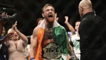 Jul 11, 2015; Las Vegas, NV, USA; Conor McGregor (blue gloves) celebrates after defeating Chad Mendes (not pictured) during their interim featherweight title bout during UFC 189 at MGM Grand Garden Arena. McGregor won via second round TKO. Mandatory Credit: Joe Camporeale-USA TODAY Sports