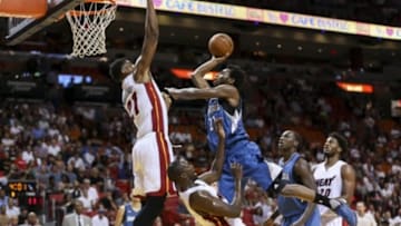 Nov 17, 2015; Miami, FL, USA; Minnesota Timberwolves guard Andrew Wiggins (right) collides into Miami Heat forward Luol Deng (bottom) as Miami Heat center Hassan Whiteside (left) blocks the basket during the first half at American Airlines Arena. Mandatory Credit: Steve Mitchell-USA TODAY Sports