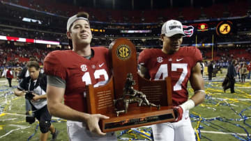 Dec 5, 2015; Atlanta, GA, USA; Alabama Crimson Tide quarterback David Cornwell (12) and Christian Miller (47) carry the trophy after the 2015 SEC Championship Game at the Georgia Dome. Alabama won 29-15. Mandatory Credit: Jason Getz-USA TODAY Sports