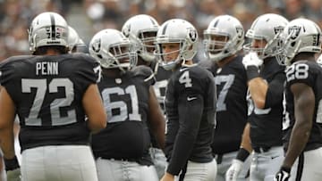 Sep 13, 2015; Oakland, CA, USA; Oakland Raiders quarterback Derek Carr (4) stands in the team huddle before taking a snap against the Cincinnati Bengals in the first quarter at O.co Coliseum. Mandatory Credit: Cary Edmondson-USA TODAY Sports