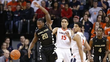 Dec 30, 2015; Charlottesville, VA, USA; Virginia Cavaliers guard Malcolm Brogdon (15) and forward Isaiah Wilkins (21) knock the ball away from Oakland Golden Grizzlies guard Kay Felder (20) during the second half at John Paul Jones Arena. The Cavaliers won 71-58. Mandatory Credit: Amber Searls-USA TODAY Sports