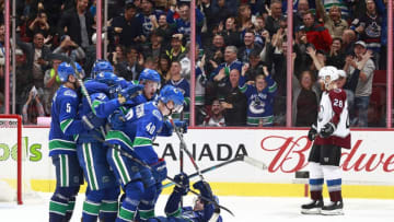 VANCOUVER, BC - NOVEMBER 2: Ian Cole #28 of the Colorado Avalanche looks on as Elias Pettersson #40 of the Vancouver Canucks is congratulated by teammates after scoring during their NHL game at Rogers Arena November 2, 2018 in Vancouver, British Columbia, Canada. (Photo by Jeff Vinnick/NHLI via Getty Images)"n
