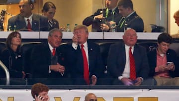 ATLANTA, GA - JANUARY 08: U.S. President Donald Trump talks to Arthur Blank, owner of the Atlanta Falcons, and his wife Stephanie, during the game between the Georgia Bulldogs and Alabama Crimson Tide in the CFP National Championship presented by AT&T at Mercedes-Benz Stadium on January 8, 2018 in Atlanta, Georgia. (Photo by Mike Zarrilli/Getty Images)