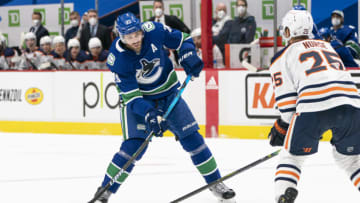 VANCOUVER, BC - MARCH 13: Brandon Sutter #20 of the Vancouver Canucks tries to shoot the puck past Darnell Nurse #25 of the Edmonton Oilers during NHL action at Rogers Arena on March 13, 2021 in Vancouver, Canada. (Photo by Rich Lam/Getty Images)