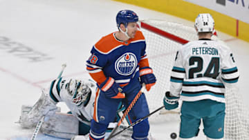 Apr 13, 2023; Edmonton, Alberta, CAN; Edmonton Oilers left winger Zach Hyman (18) stands in front of San Jose Sharks goalie James Reimer (47) as Sharks centre Jacob Peterson (24) looks on during the first period at Rogers Place. Mandatory Credit: Walter Tychnowicz-USA TODAY Sports
