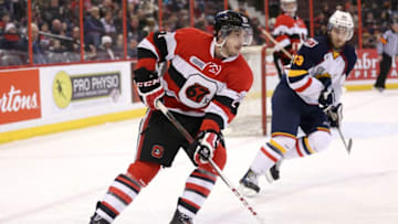 OTTAWA, ON - MARCH 13: Jacob Middleton #21 of the Ottawa 67's skates with the puck against Mitchell Theoret #23 of the Barrie Colts during an OHL game at Canadian Tire Centre on March 13, 2014 in Ottawa, Ontario, Canada. (Photo by Jana Chytilova/Freestyle Photography/Getty Images)