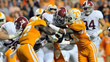 Oct 25, 2014; Knoxville, TN, USA; Alabama Crimson Tide running back T.J. Yeldon (4) is tackled by Tennessee Volunteers defensive back Justin Coleman (27) and defensive back Cameron Sutton (23) during the first half game at Neyland Stadium. Mandatory Credit: Jim Brown-USA TODAY Sports
