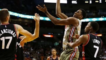 Nov 8, 2015; Miami, FL, USA; Miami Heat center Hassan Whiteside (21) shoots the ball as Toronto Raptors guard Kyle Lowry (7) and center Jonas Valanciunas (17) defend in the second half at American Airlines Arena. The Heat won 96-76. Mandatory Credit: Robert Mayer-USA TODAY Sports