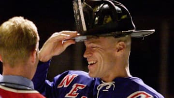 UNITED STATES - OCTOBER 07: New York Rangers' captain Mark Messier puts on the helment of Fire Department Chief of Special Operations Command Ray Downey at Madison Square Garden. FDNY team captain Larry McGee of Engine 66 presented Messier with the helmet in a ceremony before the Rangers played the Buffalo Sabres., (Photo by Corey Sipkin/NY Daily News Archive via Getty Images)