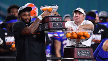 MIAMI, FLORIDA - DECEMBER 30: Lamical Perine #2 raises the MVP Trophy and Head Coach Dan Mullen of the Florida Gators celebrates after winning the Capital One Orange Bowl against the Virginia Cavaliers at Hard Rock Stadium on December 30, 2019 in Miami, Florida. (Photo by Mark Brown/Getty Images)