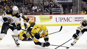 Jan 19, 2020; Pittsburgh, Pennsylvania, USA; Boston Bruins left wing Jake DeBrusk (74) and left wing Anders Bjork (10) fight for the puck against Pittsburgh Penguins left wing Brandon Tanev (13) during the third period at PPG PAINTS Arena. The Penguins won 4-3. Mandatory Credit: Charles LeClaire-USA TODAY Sports