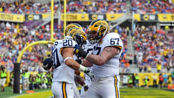 Jan 1, 2016; Orlando, FL, USA; Michigan Wolverines running back Drake Johnson (20) and offensive lineman Kyle Kalis (67) celebrate a touchdown against the Florida Gators in the 2016 Citrus Bowl at Orlando Citrus Bowl Stadium. Mandatory Credit: Jim Dedmon-USA TODAY Sports