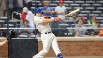 Jun 25, 2014; New York, NY, USA; New York Mets third baseman David Wright (5) hits a single against the Oakland Athletics during the sixth inning of a game at Citi Field. Mandatory Credit: Brad Penner-USA TODAY Sports