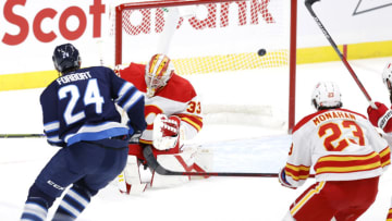 Feb 2, 2021; Winnipeg, Manitoba, CAN.; Winnipeg Jets defenseman Derek Forbort (24) scores on Calgary Flames goaltender David Rittich (33) in the first period at Bell MTS Place. Mandatory Credit: James Carey Lauder-USA TODAY Sports