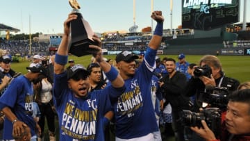 Oct 15, 2014; Kansas City, MO, USA; Kansas City Royals second baseman Omar Infante (left) celebrates with catcher Salvador Perez (right) with the American League championship trophy after game four of the 2014 ALCS playoff baseball game against the Baltimore Orioles at Kauffman Stadium. The Royals swept the Orioles to advance to the World Series. Mandatory Credit: Denny Medley-USA TODAY Sports