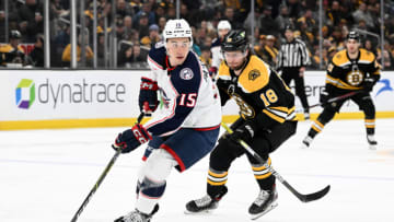 Mar 30, 2023; Boston, Massachusetts, USA; Columbus Blue Jackets defenseman Gavin Bayreuther (15) controls the puck against Boston Bruins center Pavel Zacha (18) during the first period at the TD Garden. Mandatory Credit: Brian Fluharty-USA TODAY Sports